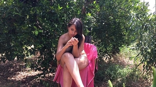 Chica joven de eighteen años sentada desnuda entre árboles